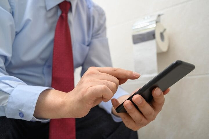Vì sao không nên dùng diện thoại khi đi tolet